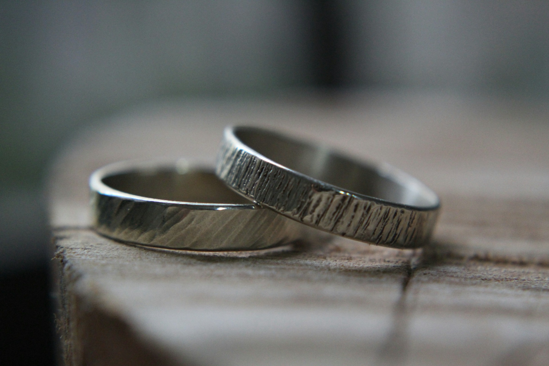 Anillos de plata texturados hechos a mano sobre madera