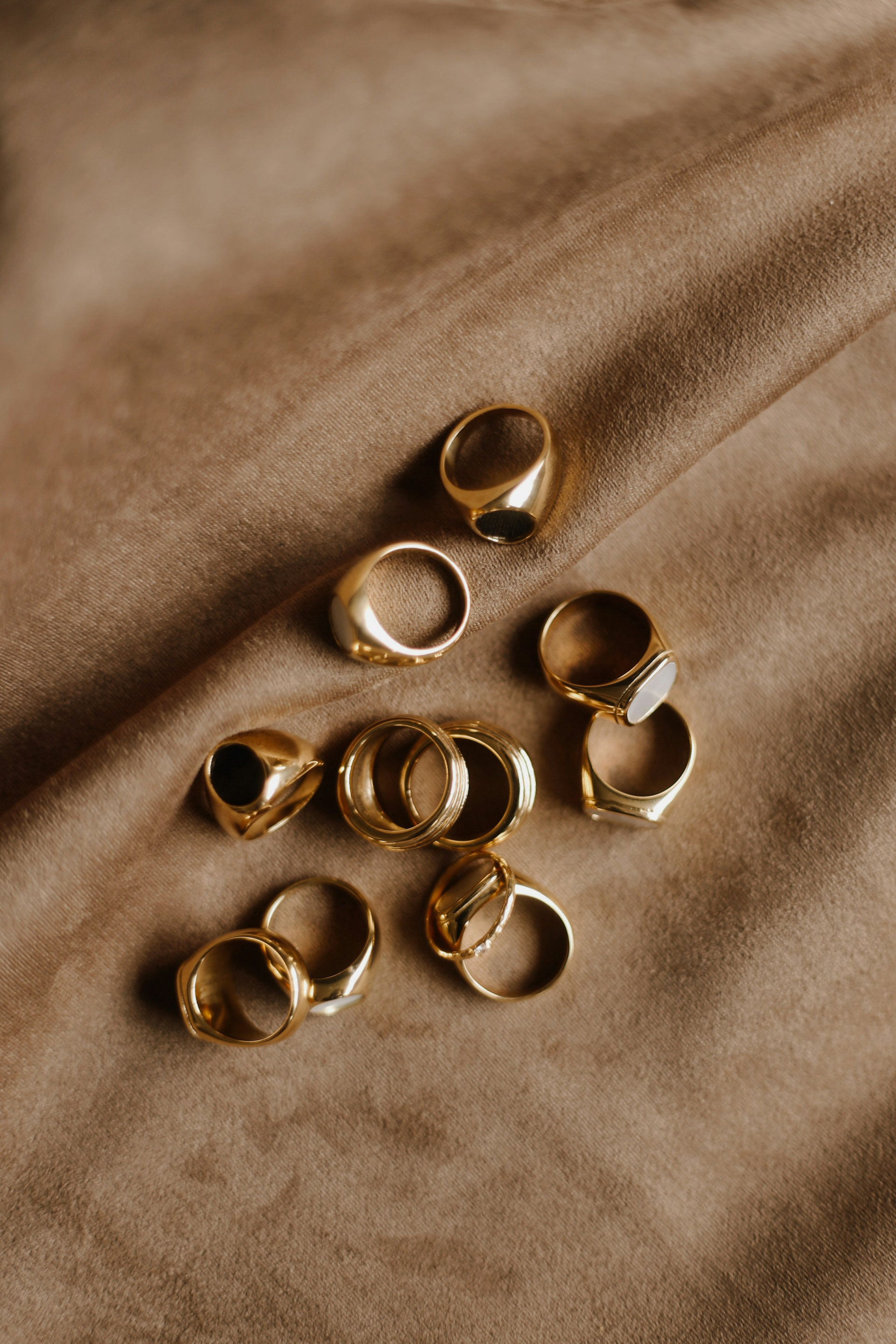 Anillos de oro sobre tela cálida iluminados con luz natural